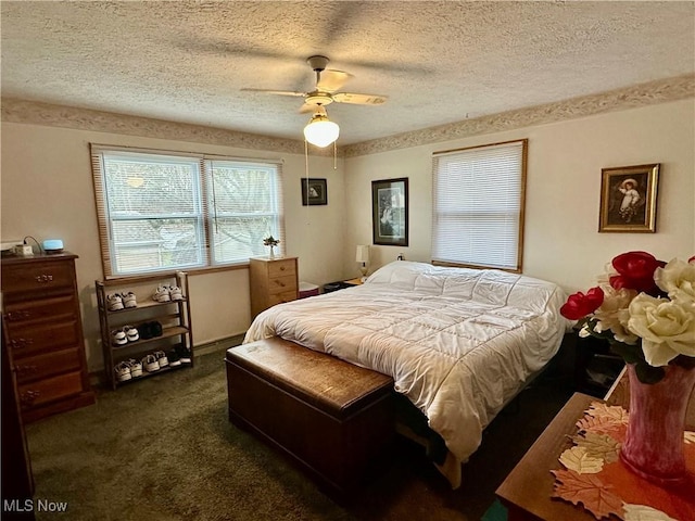 bedroom featuring dark carpet, a ceiling fan, and a textured ceiling