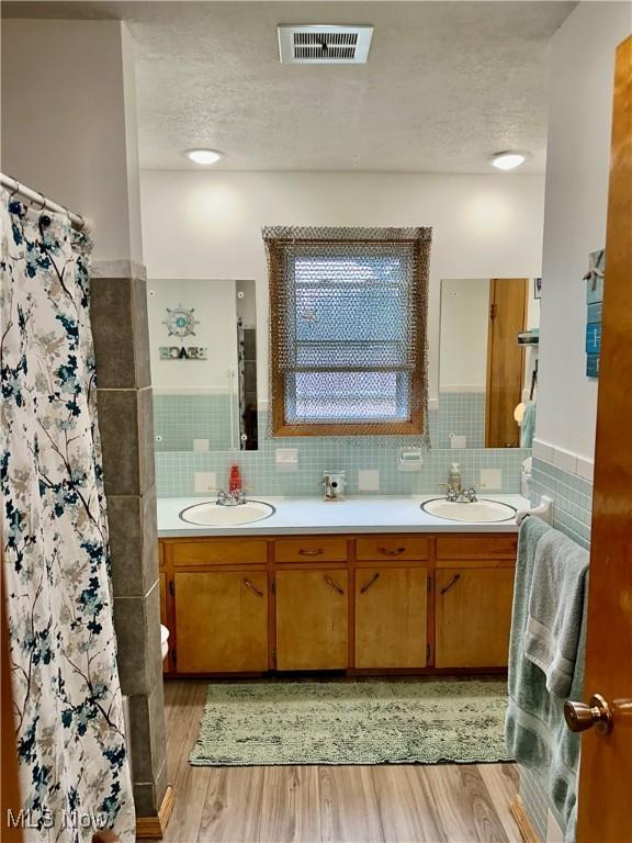 bathroom featuring visible vents, wood finished floors, and a sink