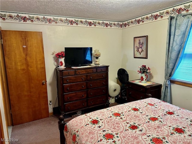 bedroom featuring a textured ceiling and carpet