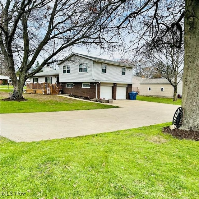 tri-level home featuring a front lawn, concrete driveway, brick siding, and a garage