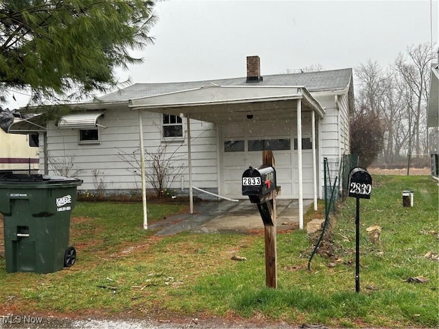 back of house featuring a garage and a yard