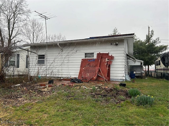 rear view of property featuring a lawn