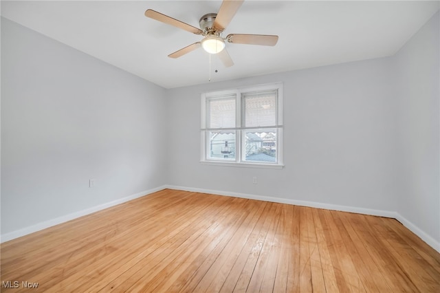 spare room featuring a ceiling fan, hardwood / wood-style flooring, and baseboards