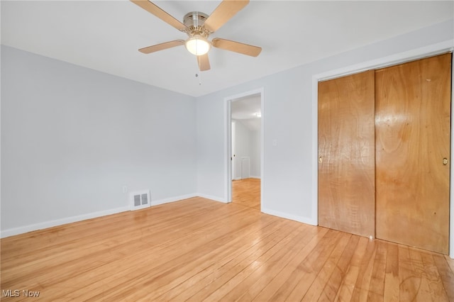 unfurnished bedroom with a closet, light wood-type flooring, baseboards, visible vents, and ceiling fan