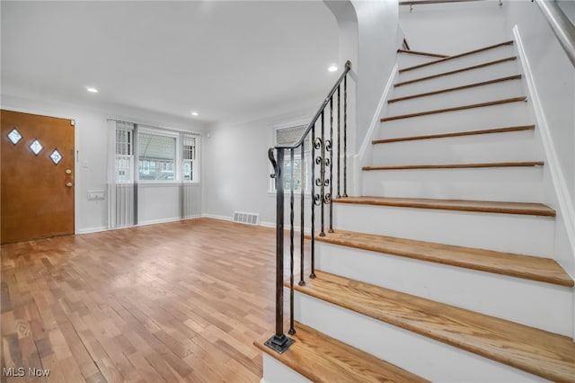 stairway featuring baseboards, visible vents, recessed lighting, and wood-type flooring