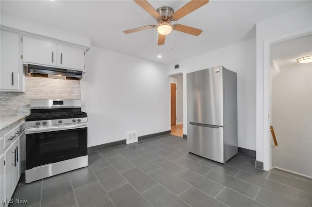 kitchen featuring a ceiling fan, tasteful backsplash, arched walkways, under cabinet range hood, and appliances with stainless steel finishes