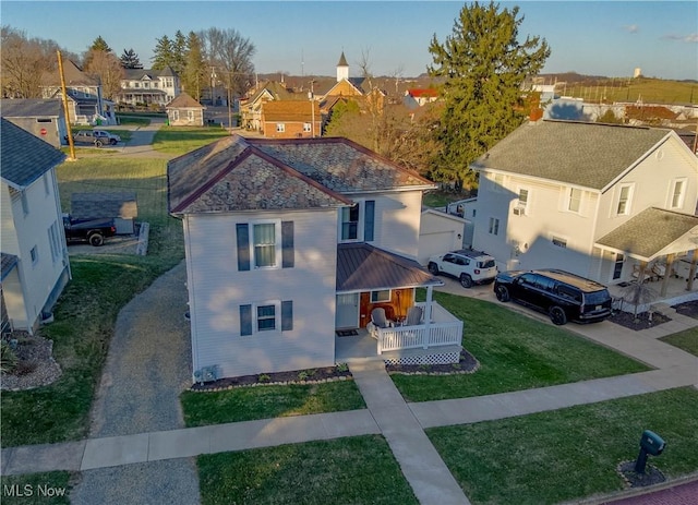 view of front of house with covered porch, a front lawn, and a residential view