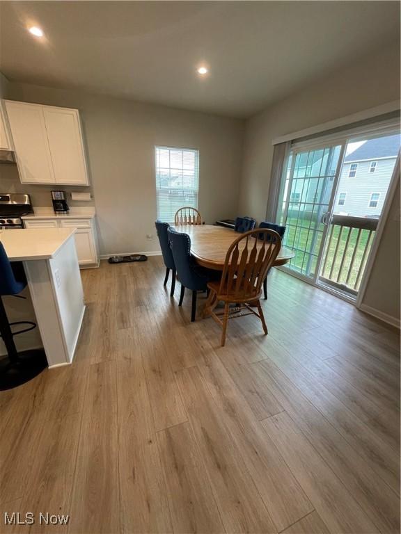 dining area with a wealth of natural light, recessed lighting, light wood-style floors, and baseboards