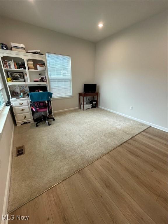 interior space with carpet, visible vents, recessed lighting, wood finished floors, and baseboards