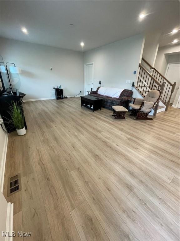 living area with recessed lighting, visible vents, baseboards, and wood finished floors