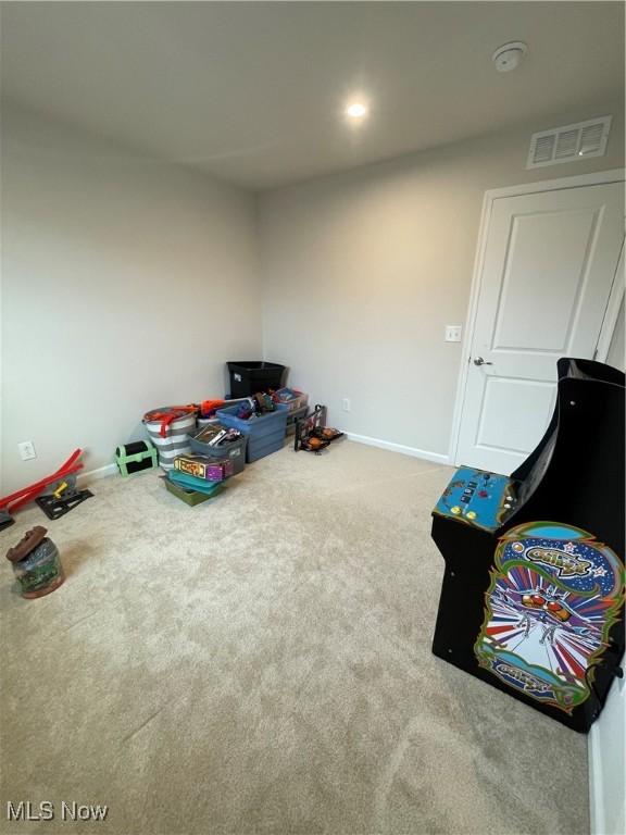 rec room with carpet, visible vents, and baseboards