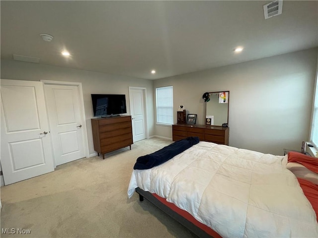 bedroom featuring visible vents, baseboards, recessed lighting, and light carpet