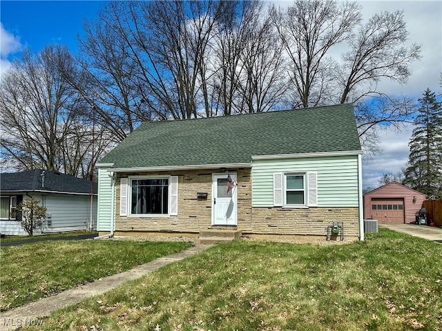 1563 Maplewood St NE, Warren, OH 44483 - view of front of property with stone siding, a detached garage, a front yard, roof with shingles, and an outbuilding