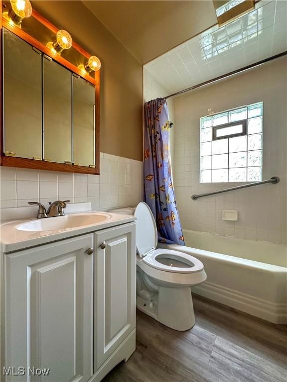 1563 Maplewood St NE, Warren, OH 44483 - full bath with vanity, shower / tub combo, tile walls, toilet, and wood finished floors