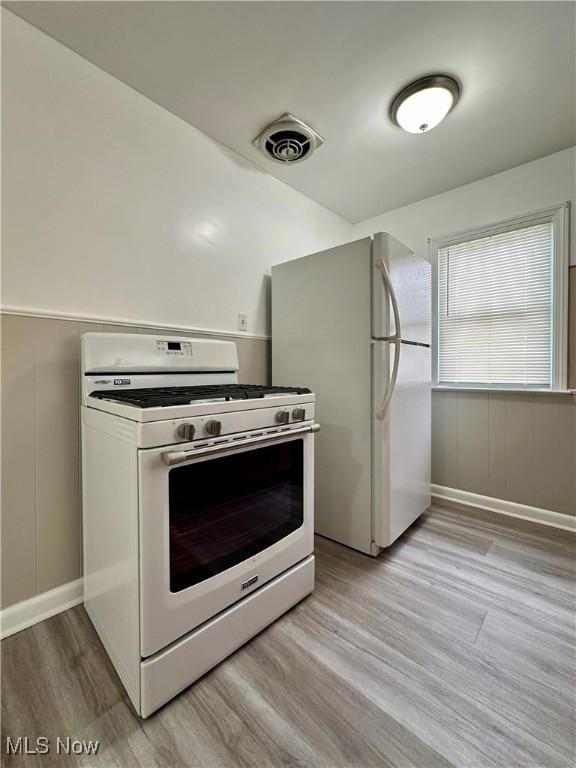 1563 Maplewood St NE, Warren, OH 44483 - kitchen featuring light wood finished floors, white appliances, and visible vents