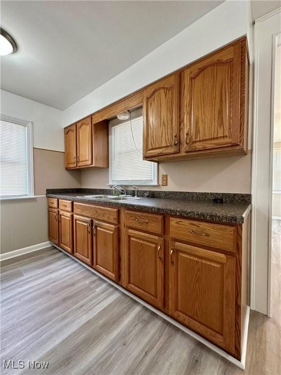 1563 Maplewood St NE, Warren, OH 44483 - kitchen featuring a sink, light wood-style floors, and brown cabinetry