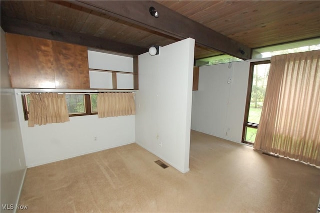 spare room with carpet, beamed ceiling, visible vents, and wood ceiling