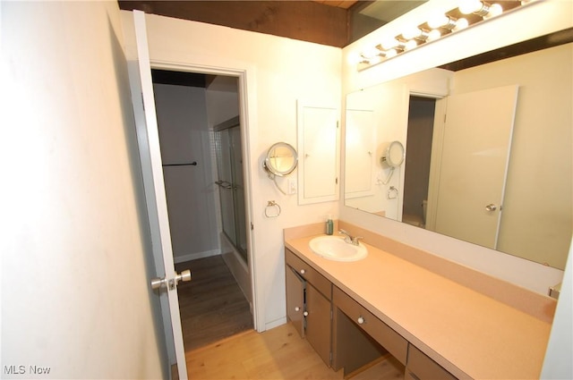full bath with wood finished floors, vanity, and a shower with shower door