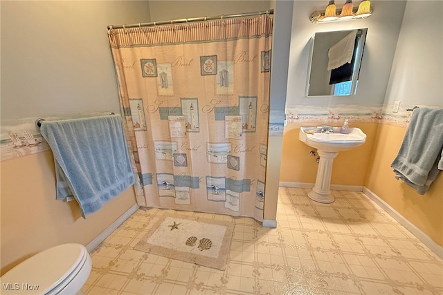 103 Southaven Ln, Kelleys Island, OH 43438 - bathroom with baseboards, toilet, tile patterned floors, and a shower with curtain