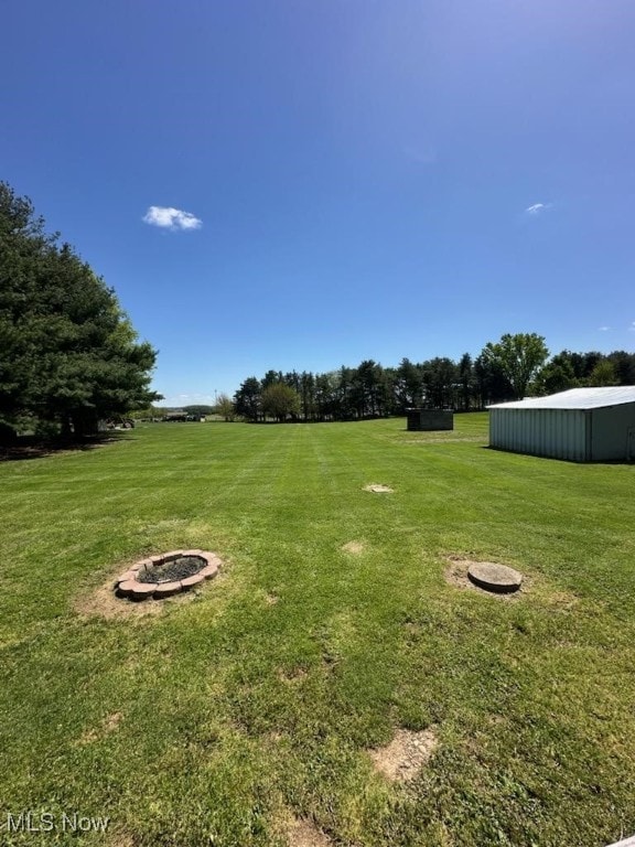 5612 Force Rd, Shreve, OH 44676 - view of grassy yard with an outbuilding and a fire pit