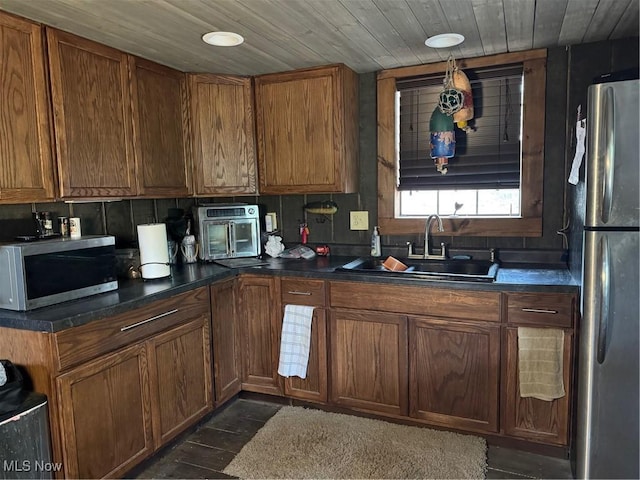 7301 Leafygreen St SW, Carrollton, OH 44615 - kitchen with dark countertops, brown cabinetry, stainless steel appliances, wood ceiling, and a sink
