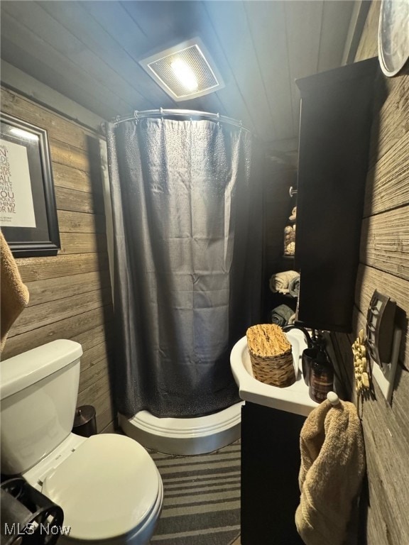 7301 Leafygreen St SW, Carrollton, OH 44615 - bathroom with vanity, a stall shower, wooden walls, toilet, and visible vents