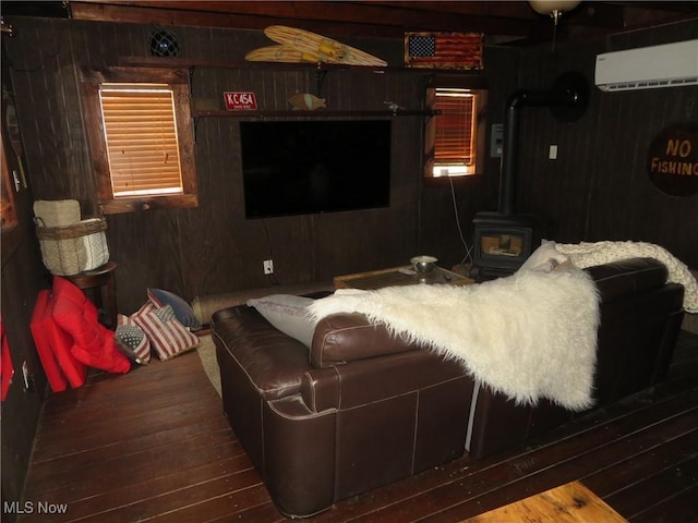 7301 Leafygreen St SW, Carrollton, OH 44615 - living room with wooden walls, a wood stove, wood finished floors, and a wall unit AC