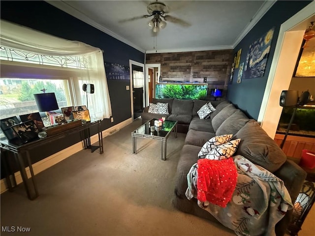 living area featuring baseboards, an accent wall, ornamental molding, and a ceiling fan
