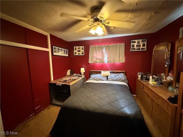 carpeted bedroom featuring ceiling fan and a textured ceiling