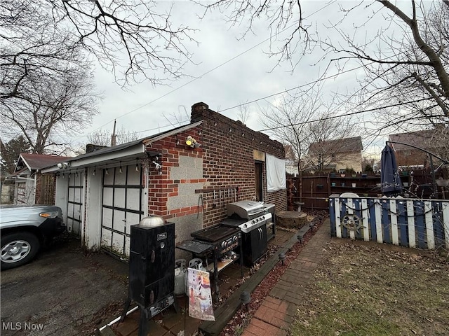 view of side of home featuring brick siding and a garage