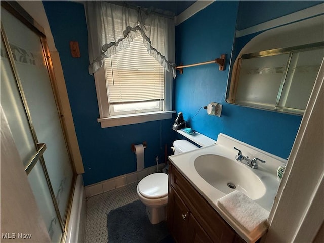 full bathroom featuring toilet, vanity, a shower stall, tile patterned flooring, and baseboards