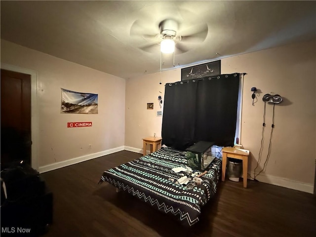 bedroom featuring baseboards, wood finished floors, and a ceiling fan