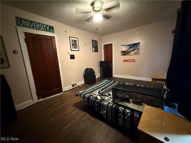 bedroom featuring baseboards, visible vents, a ceiling fan, and wood finished floors