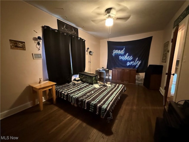 bedroom featuring baseboards, wood finished floors, and a ceiling fan