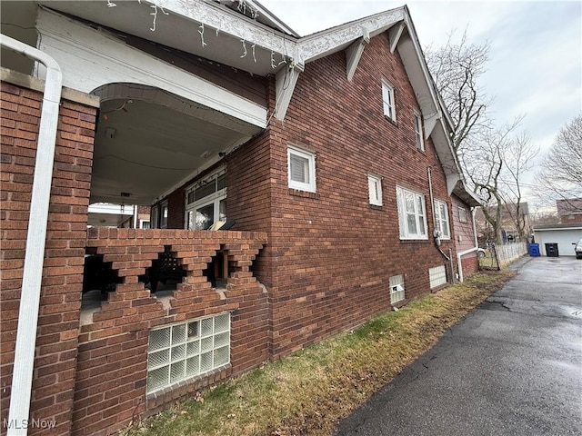view of property exterior featuring brick siding and a garage