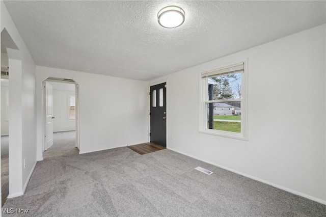 3665 Marcella Ave, Stow, OH 44224 - unfurnished room with carpet floors, arched walkways, visible vents, and a textured ceiling