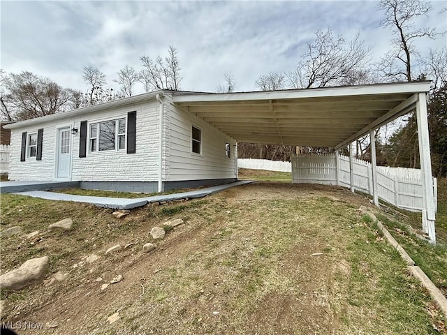 exterior space with an attached carport and fence