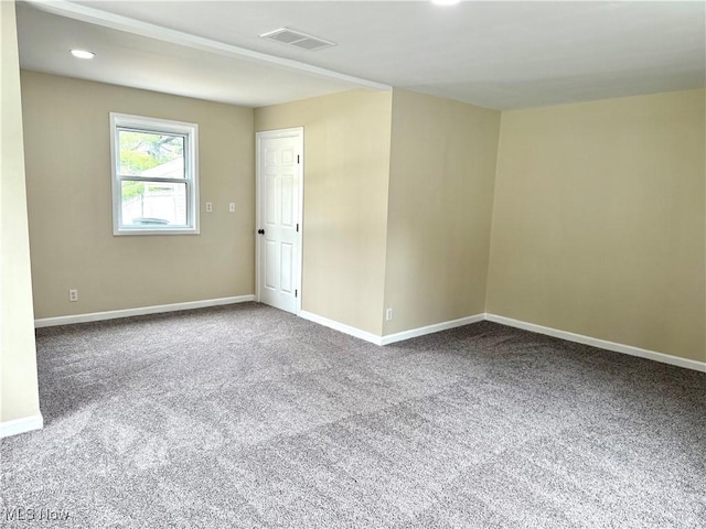 carpeted spare room with baseboards and visible vents
