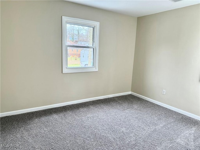 empty room featuring baseboards and carpet