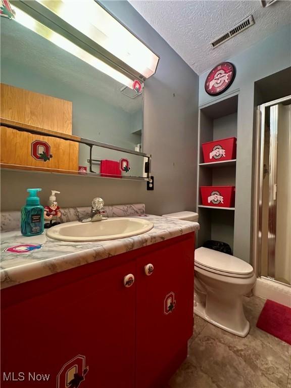 full bathroom with visible vents, a shower stall, toilet, and vanity