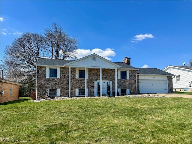 greek revival inspired property with a chimney, a front yard, brick siding, concrete driveway, and an attached garage
