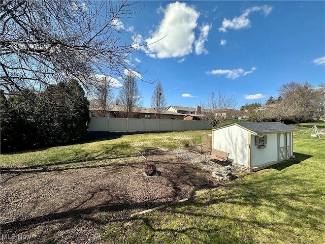 view of yard featuring an outbuilding, fence, and a storage shed