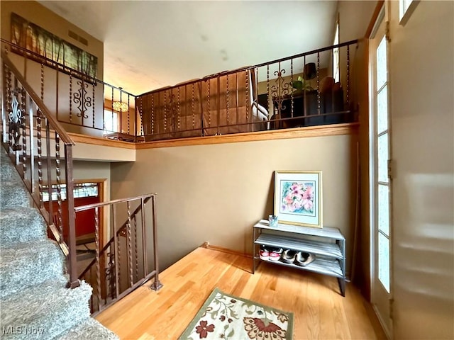 stairway featuring a wealth of natural light and wood finished floors