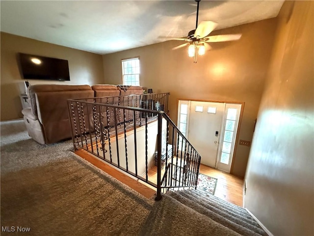 stairs with a ceiling fan, baseboards, and wood finished floors