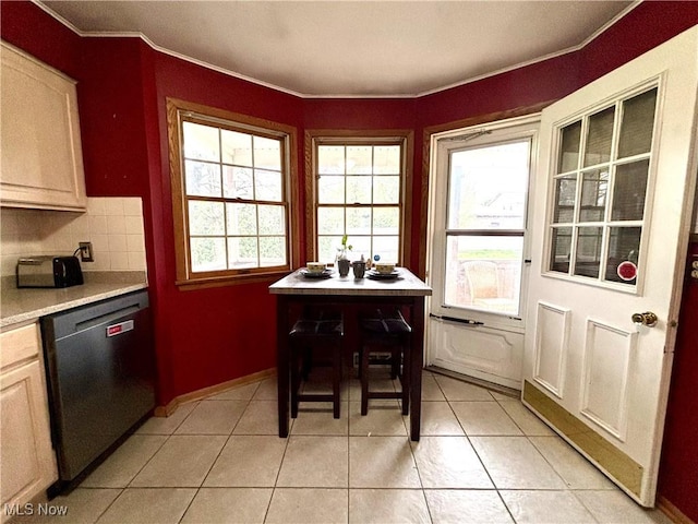 dining room with light tile patterned floors, baseboards, and ornamental molding