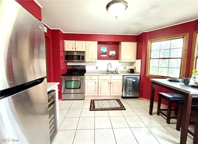 kitchen with light countertops, stainless steel appliances, light tile patterned floors, and a sink
