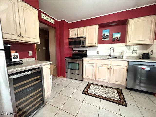 kitchen featuring beverage cooler, a sink, light countertops, and stainless steel appliances