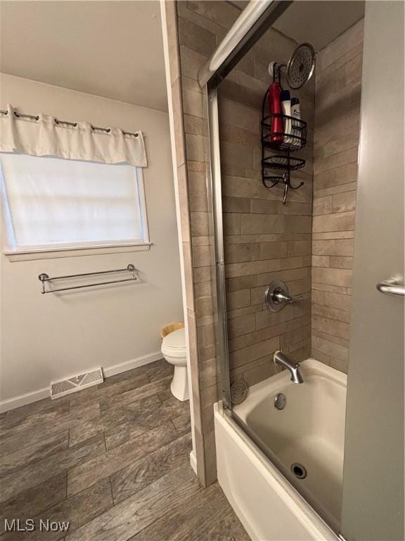 full bath with toilet, baseboards, visible vents, and washtub / shower combination