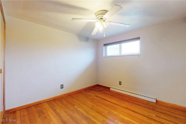 spare room with baseboards, light wood-style floors, a ceiling fan, and a baseboard radiator