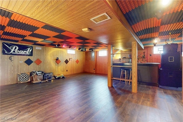 interior space featuring visible vents, wooden walls, wood finished floors, and wood ceiling